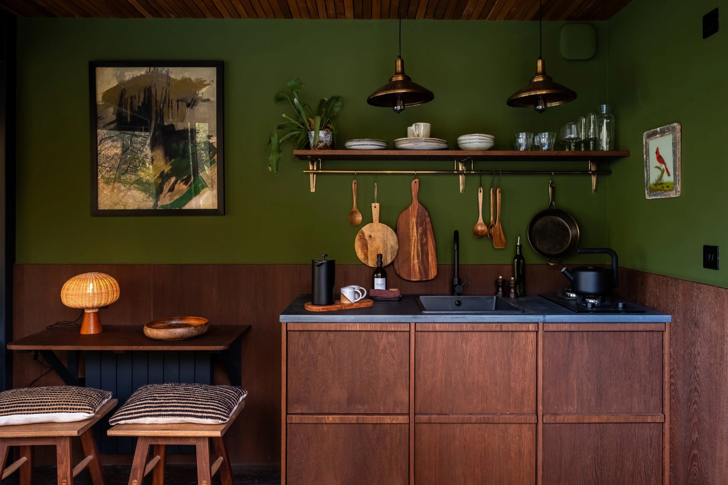 Lodge kitchenette with dark cabinetry and natural timber
